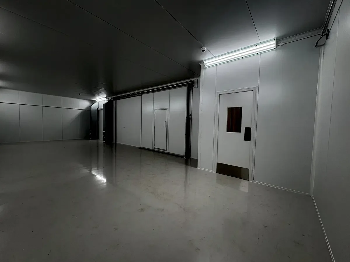 Clean room vestibule and airlock configuration showing personnel access door with glazed viewing panel and LED ceiling lighting